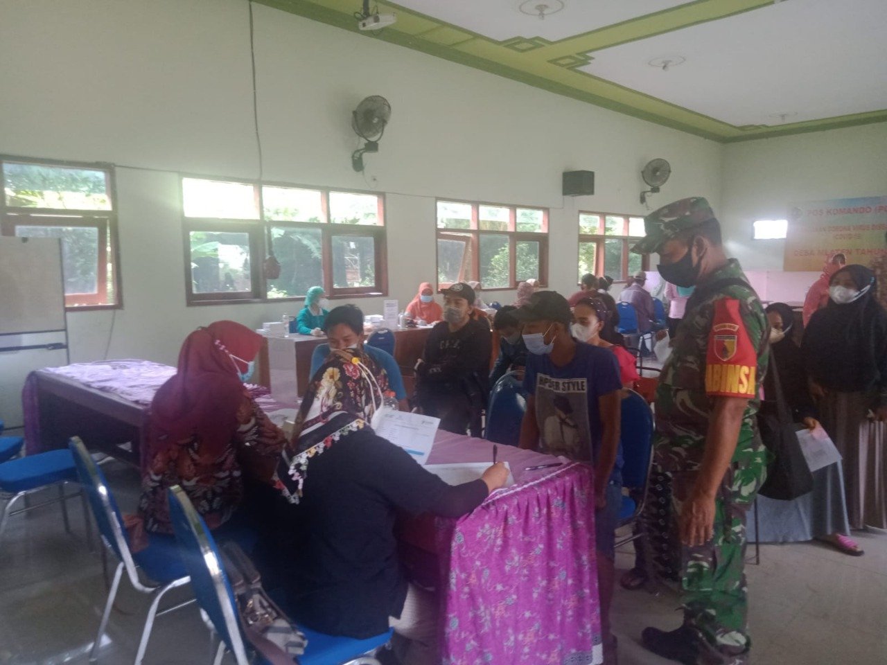 Koramil Puri Kerahkan Babinsa Kawal Layanan Vaksinasi Hingga Penyaluran Bansos