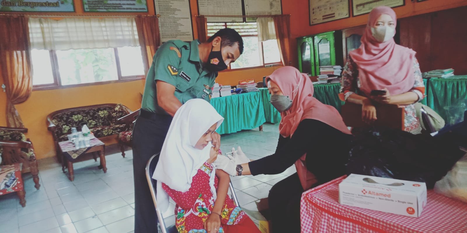 Sukseskan Program BIAS, Babinsa Koramil 0815/06 Kemlagi Dampingi Nakes Beri Imunisasi