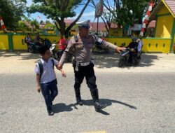 Gatur Lalin, Petugas Satlantas Polres Aceh Timur Bantu Seberangkan Anak Sekolah