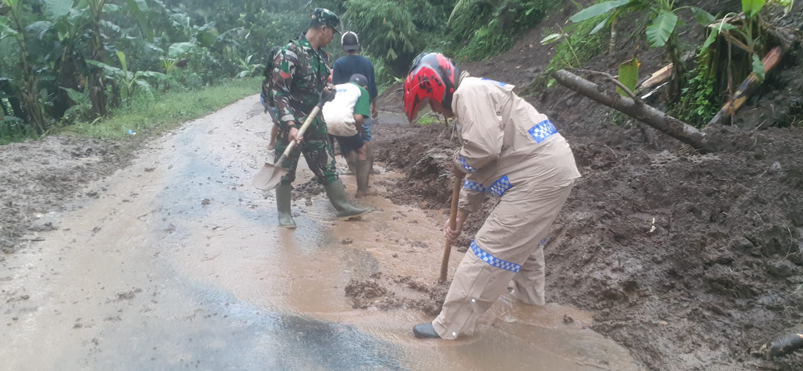 Gotong – royong Polisi dan TNI Bersama Warga Bersihkan Tebing Longsor di Banyuwangi