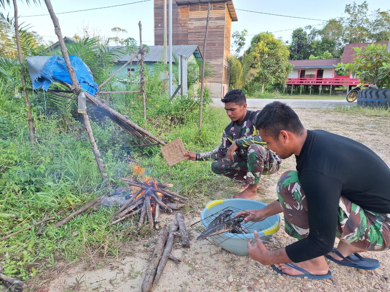 Satgas bersama warga Kampung Kelian bakar ikan ( Dok TMMD )