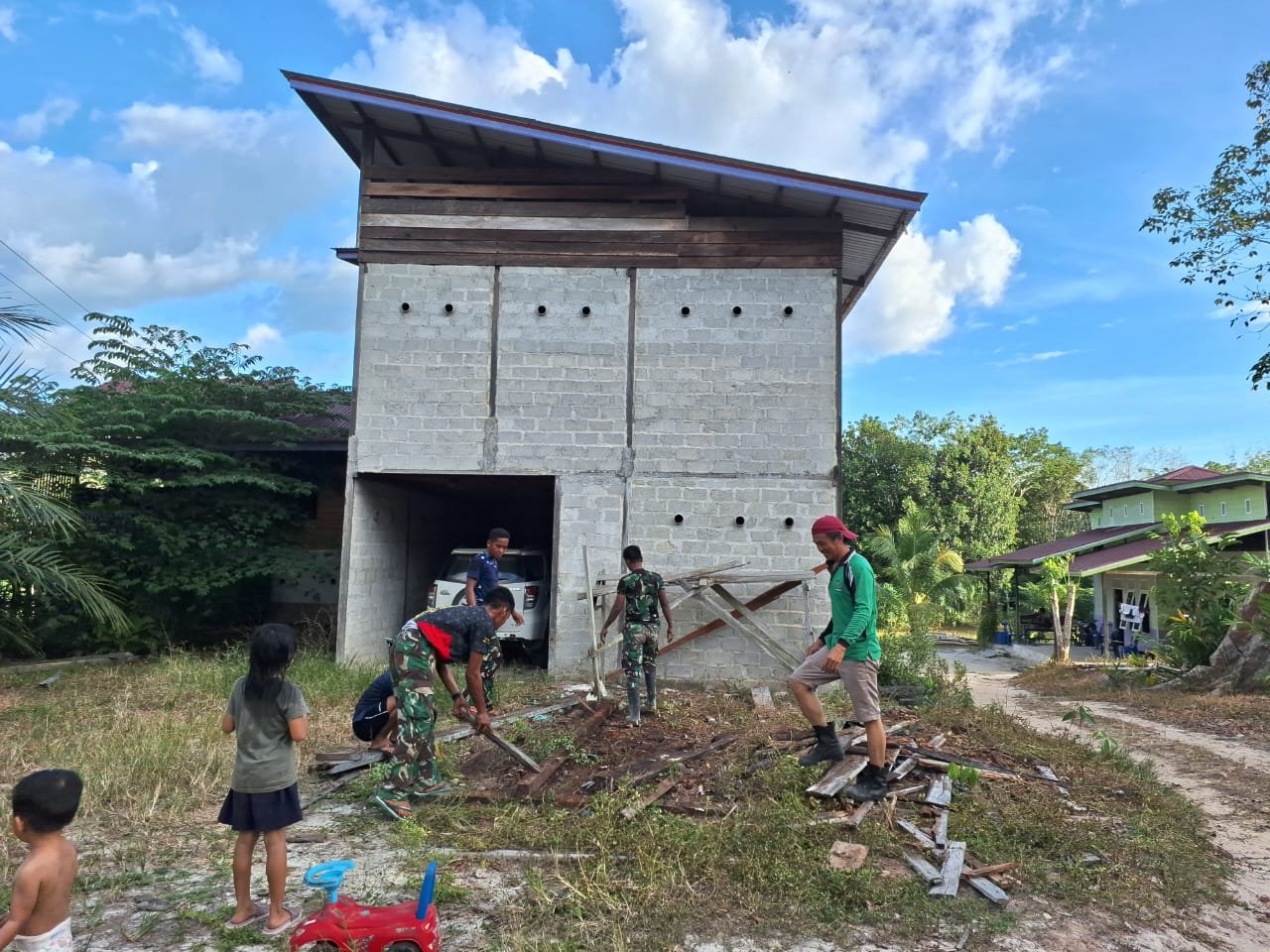 Personel Satgas TMMD bersama warga bersihkan lingkungan ( Dok TMMD )