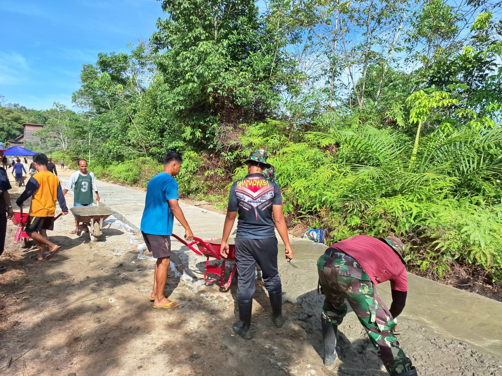 Semangat Warga Bantu Semenisasi Jalan di Kampung Kelian membuat Anggota Satgas Lebih semangat lagi