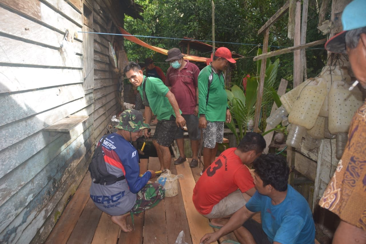 Anggota Satgas TMMD Kopda ikhwan membantu masyarakat gotong royong membuat dapur di rumah Bapak Lingur Staf adat kampung kelian