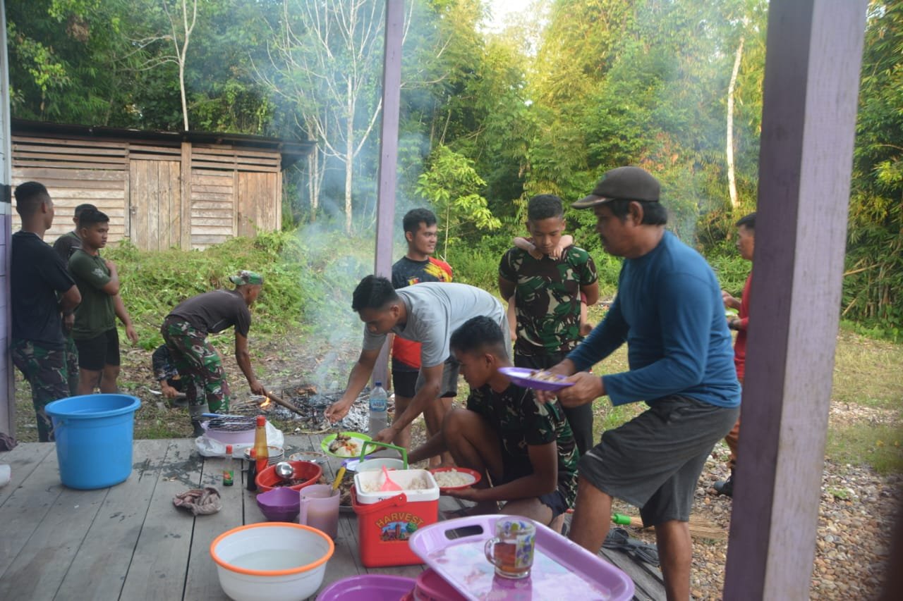 Anggota satgas makan bersama warga Setelah melaksanakan pembersihan di kampung kelian