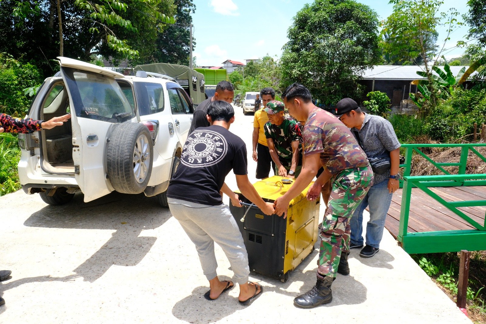 Pratu yoga bantu warga angkat genset untuk menghidukan listrik di Kantor Petinggi