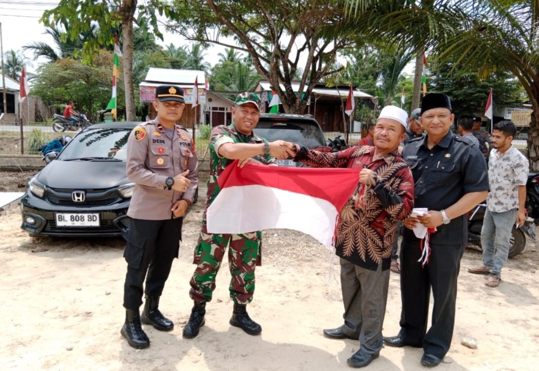 Kapolsek Peureulak Barat Bersama Muspika Bagikan Bendera Merah Putih