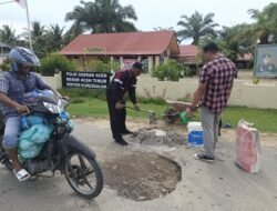 Dengan Semangat Menyambut Hari Bhayangkara Kapolsek Nurussalam Memperbaiki Jalan Berlubang
