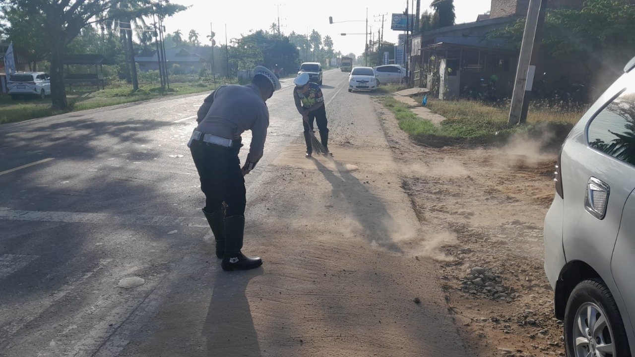 Peduli Keselamatan Pengendara, Anggota Satlantas Polres Aceh Timur Bersihkan Material Kerikil di Jalan