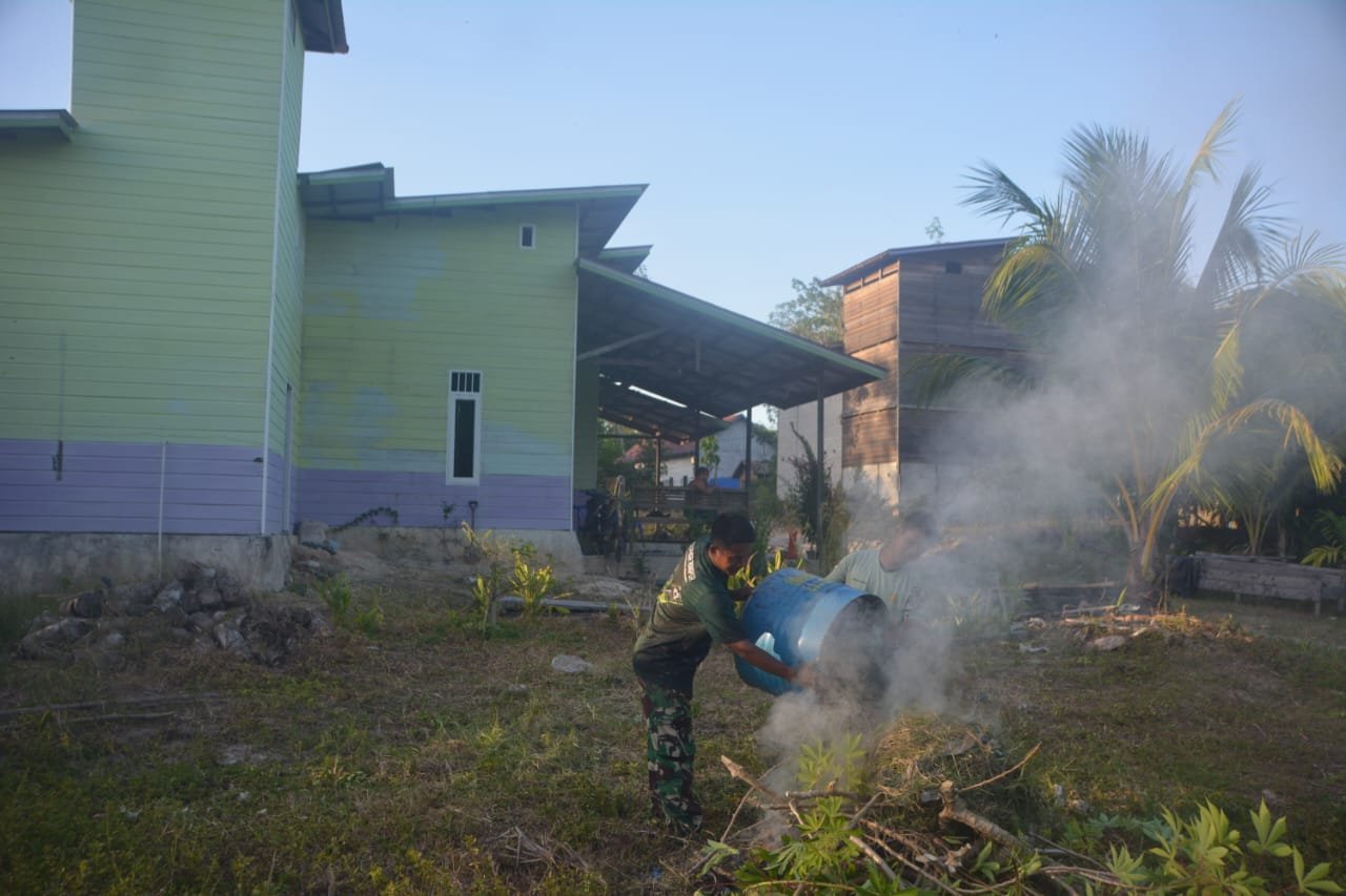 Personel Satgas TMMD saat membantu membersihkan lingkungan sekitar rumah tempat Satgas menginap.( Dok TMMD)