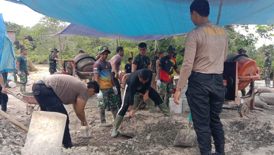 Polisi turun tangan membantu TNI mengerjakan kegiatan semenisasi.( R.S,)